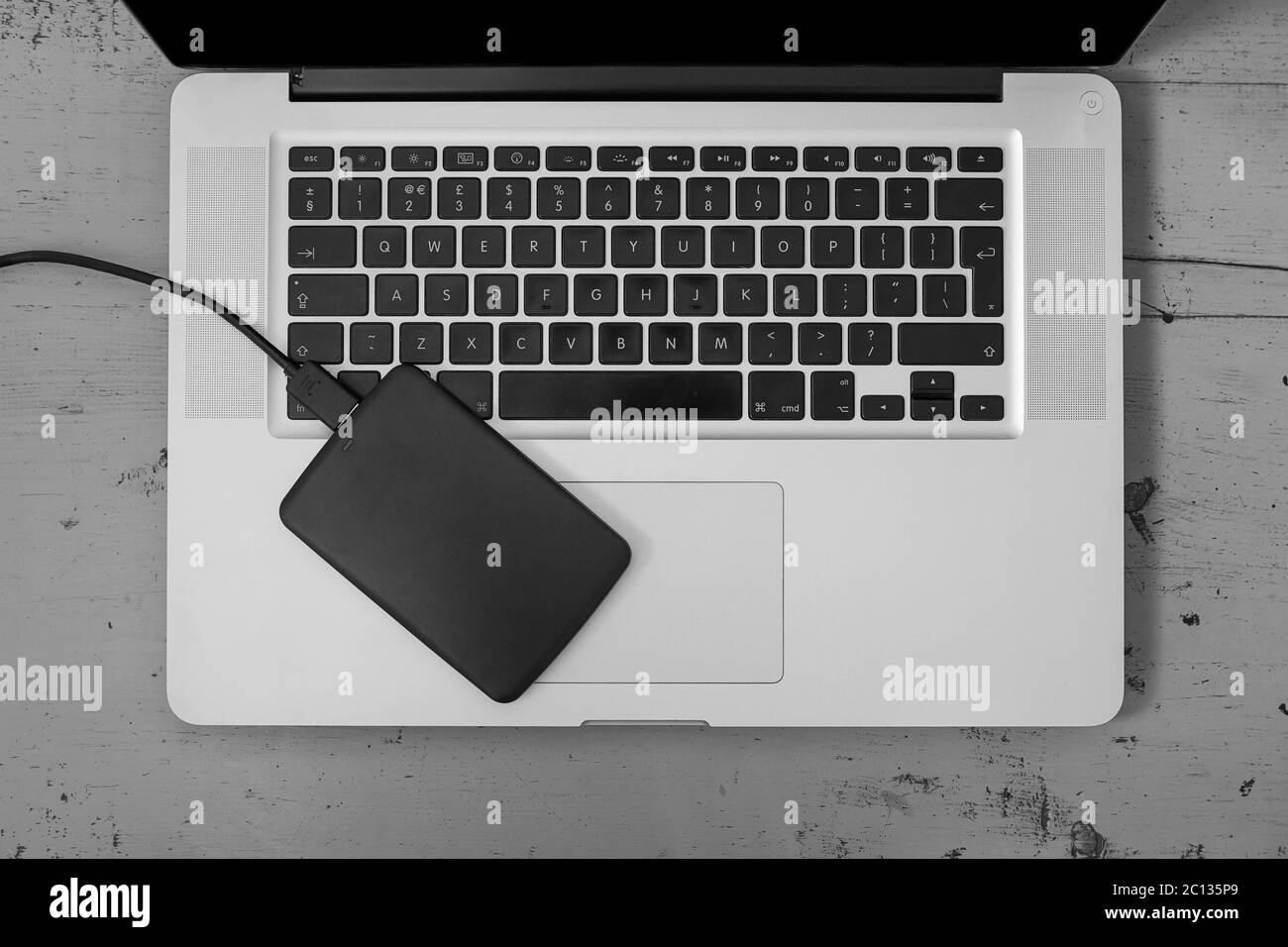 Disco rigido esterno sulla tastiera del notebook Foto Stock