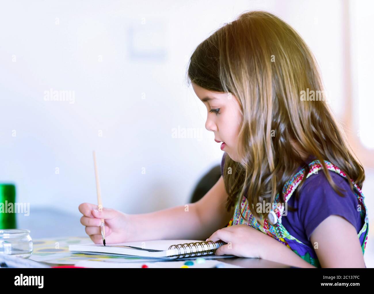 Ritratto di bella ragazza concentrata mentre dipingendo Foto Stock