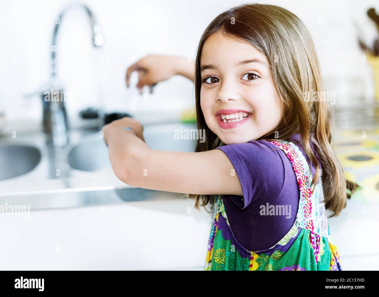 bambino lavando le mani in cucina Foto Stock