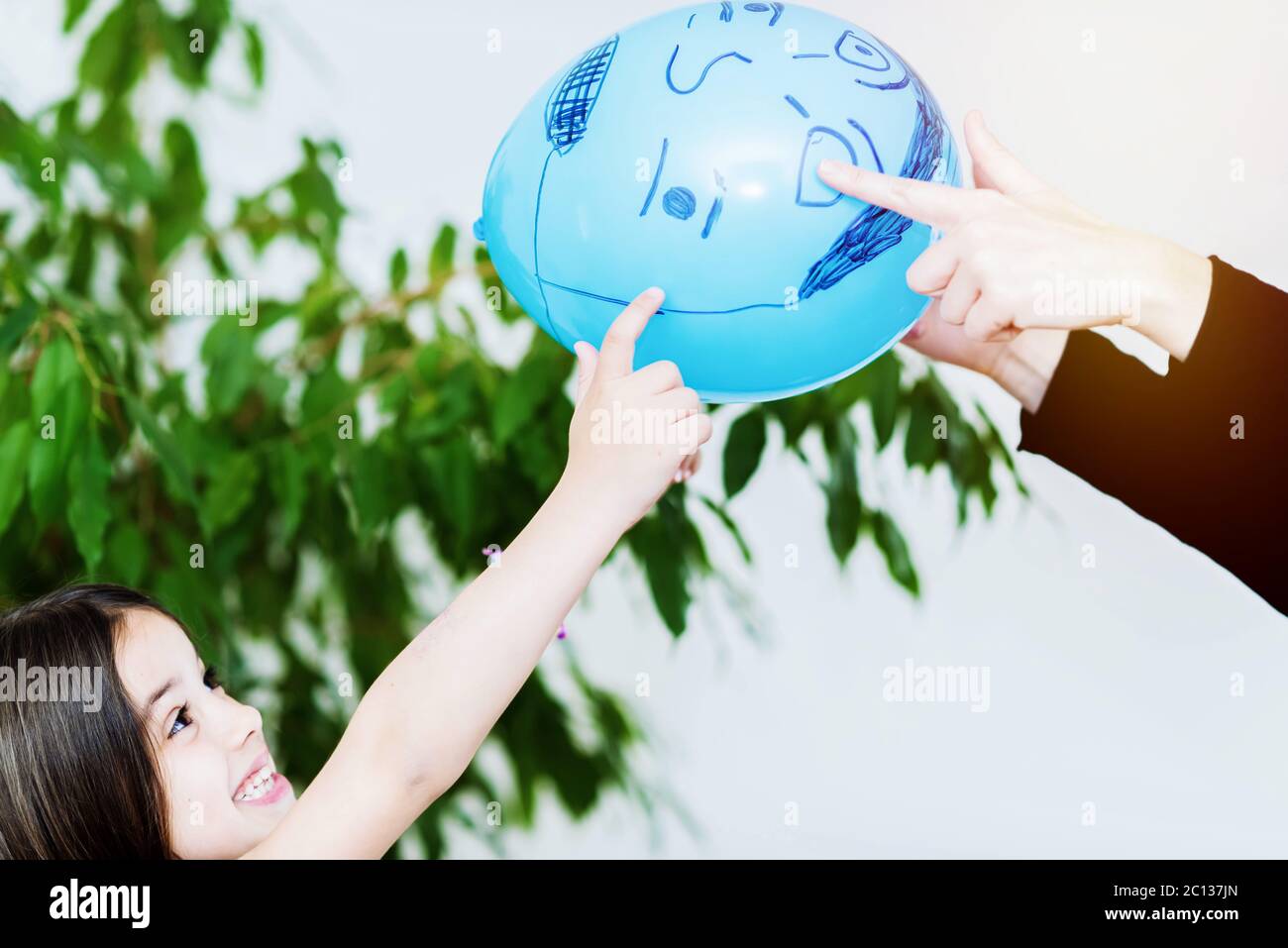 felice bambino cute che gioca a palloncino con la madre Foto Stock