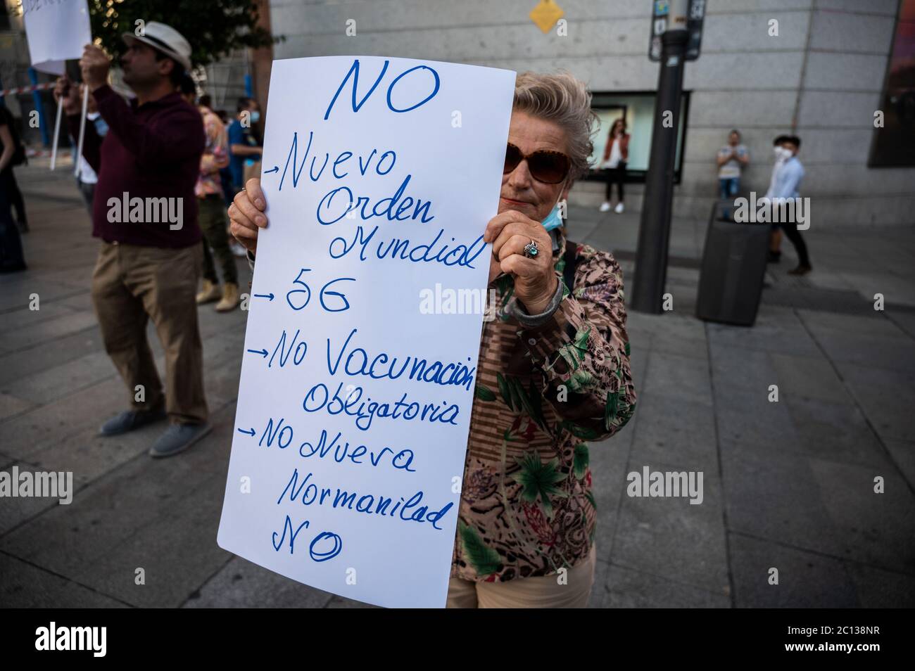 Madrid, Spagna. 13 Giugno 2020. Madrid, Spagna. 13 giugno 2020. Una donna con un cartello durante una protesta contro la nuova normalità e la teoria della cospirazione del nuovo ordine mondiale. La targhetta recita: No al nuovo Ordine Mondiale, al 5G, no alla vaccinazione obbligatoria, no alla nuova normalità. Credit: Marcos del Mazo/Alamy Live News Foto Stock