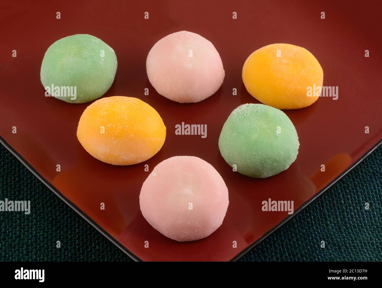 Fragola, tè verde e gelato al mango palline di mochi su piatto da dessert rosso Foto Stock