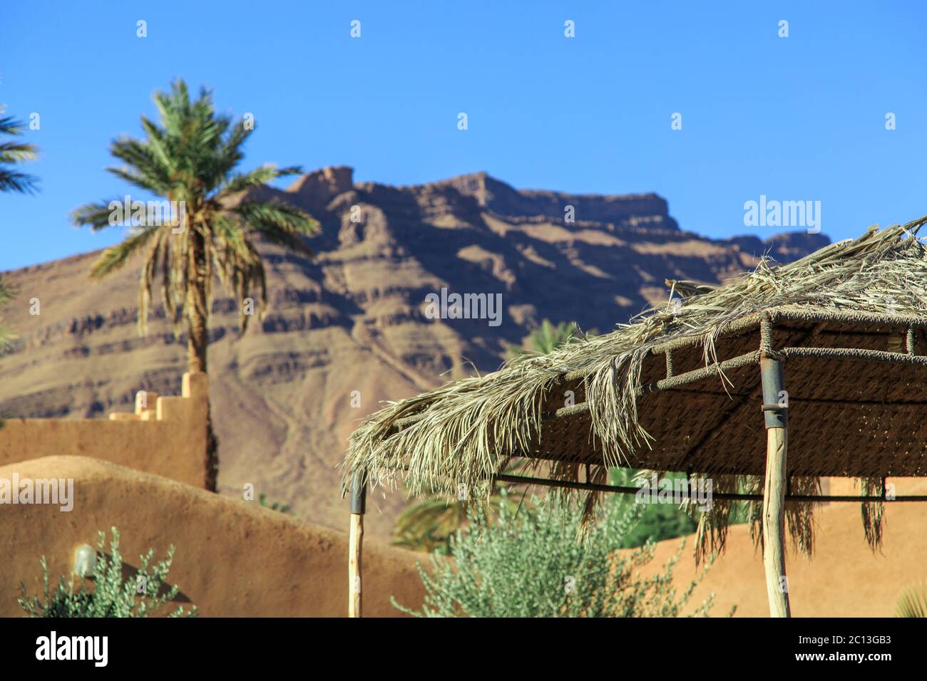 Tetto di una capanna fatta di foglia di palma con montagna sullo sfondo Foto Stock