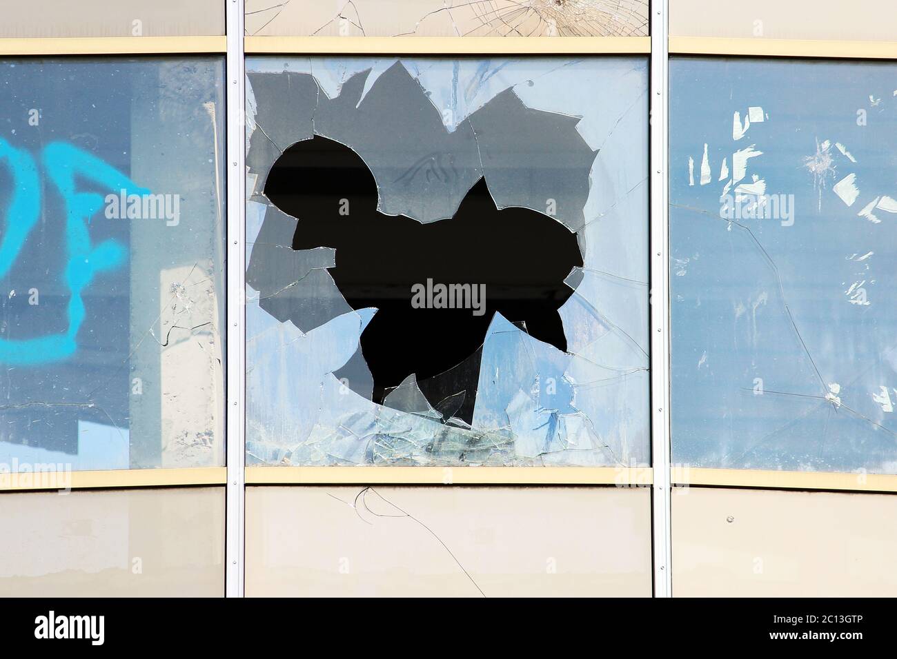 Vandalo finestre rotte in un abbandonato il centro shopping di costruzione che sorge non custodito. Foto Stock