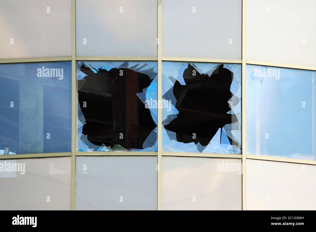 Vandalo finestre rotte in un abbandonato il centro shopping di costruzione che sorge non custodito. Foto Stock