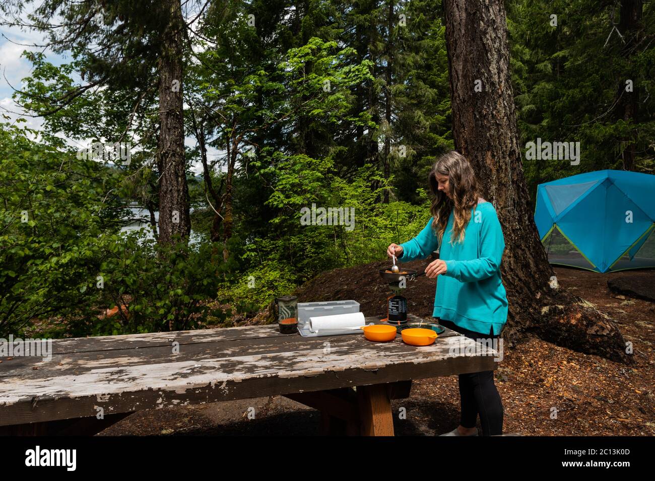 Una femmina di mezza età che prepara un pasto per due su un Jetboil mentre si accampano Foto Stock