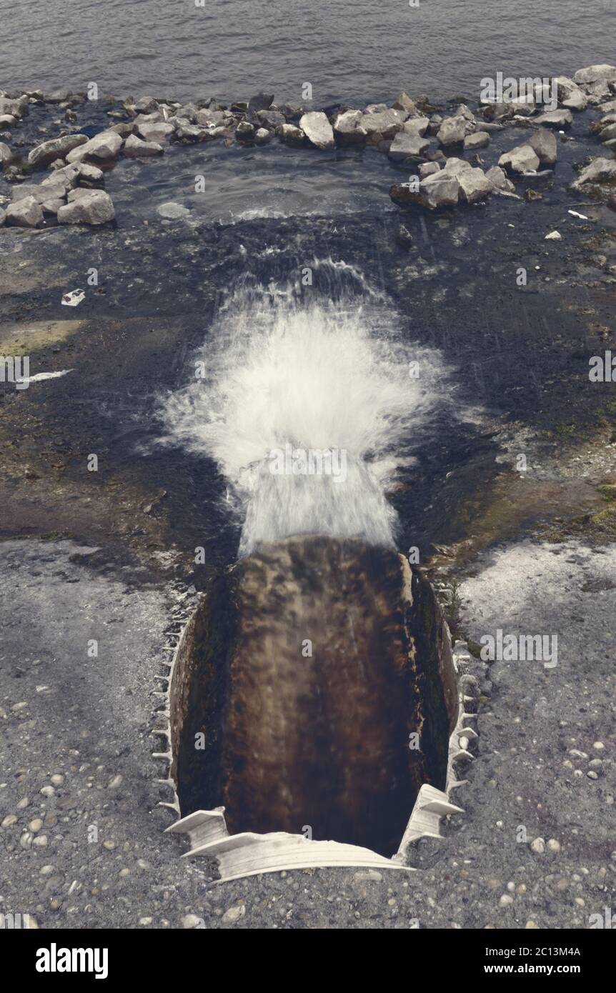 Grande tubo di scarico fognario di cemento che si svuota nel fiume Foto Stock