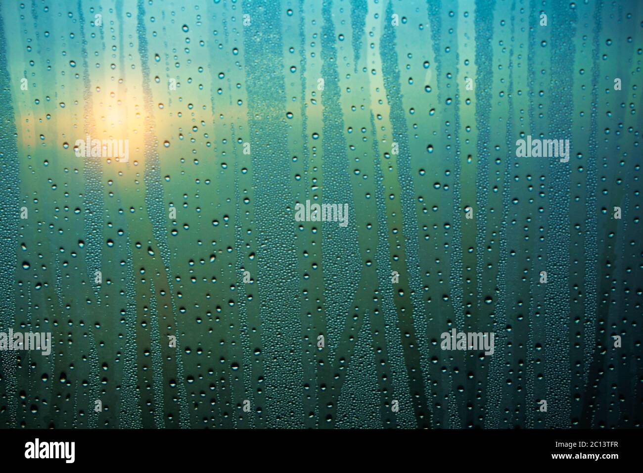Gocce d'acqua sul vetro con l'alba. Foto Stock