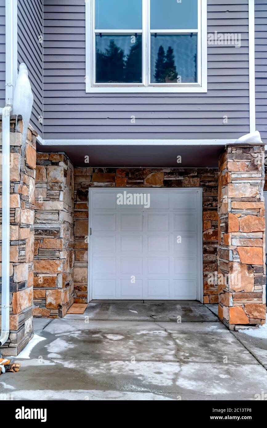 Porta del garage con pannelli bianchi di casa con lato grigio e parete  esterna in pietra Foto stock - Alamy