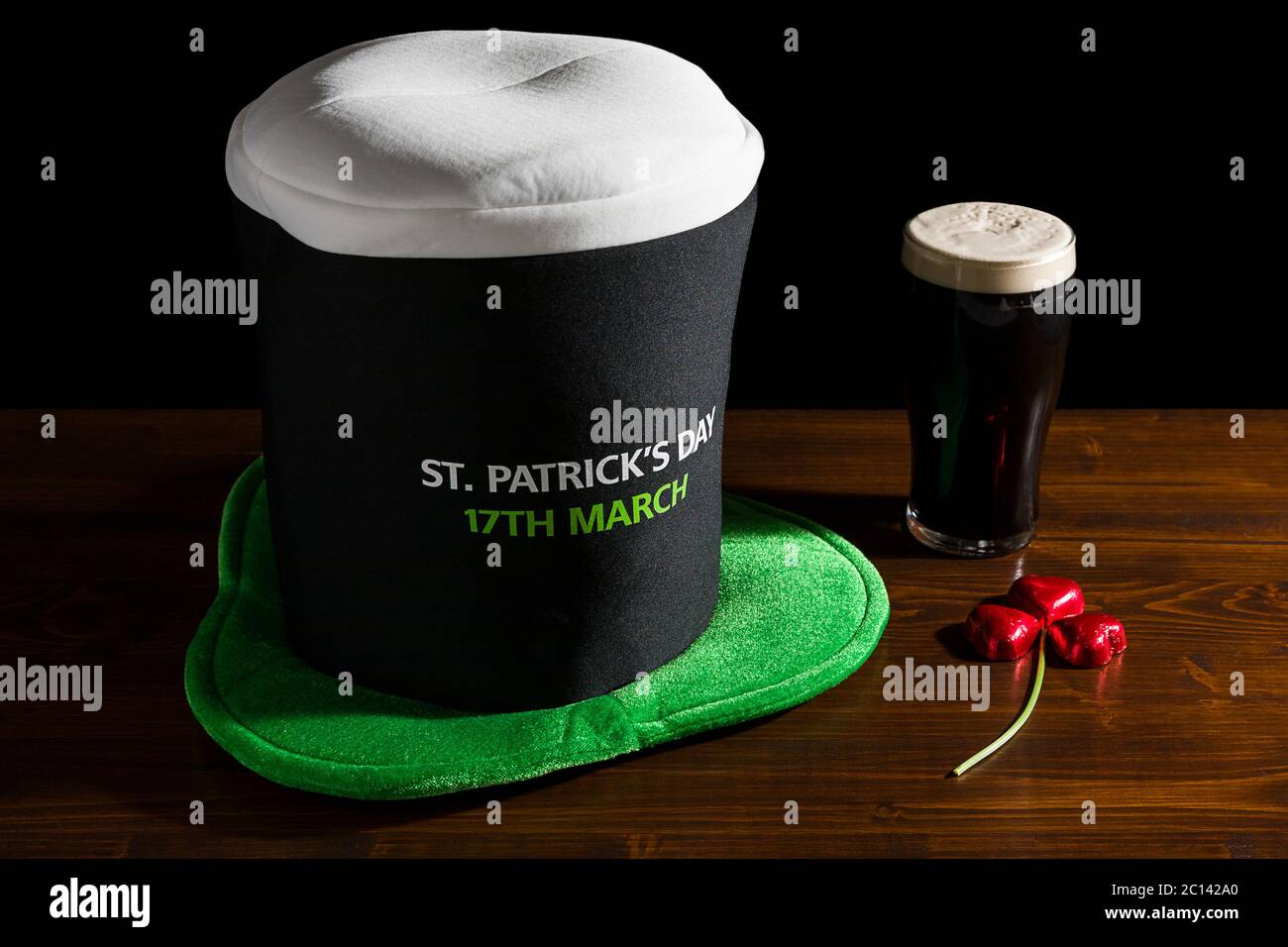 St Patrick giornata con una pinta di birra nera, cappello e shamrock Foto Stock
