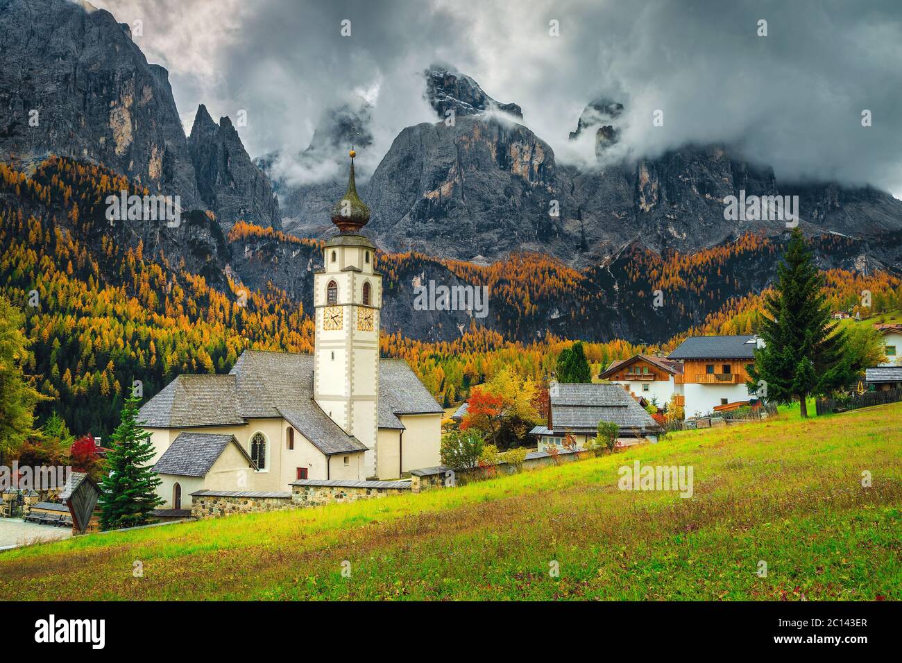 Splendido scenario montano autunnale con una graziosa chiesa nel favoloso villaggio alpino, Colfosco, Dolomiti, Italia, Europa Foto Stock