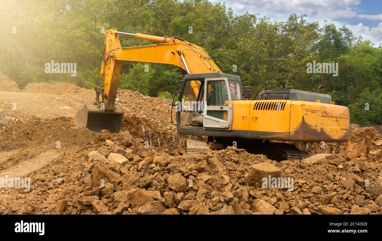 Gli escavatori dragano rocce minerarie da utilizzare come materie prime per la costruzione di edifici e case in città Foto Stock