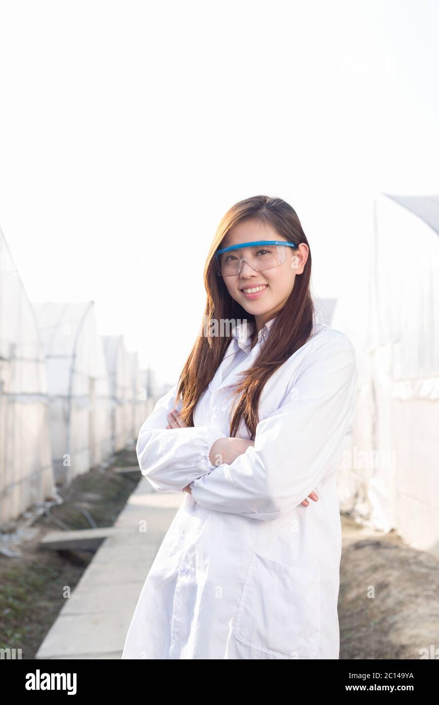 Giovane bella donna asiatica lavora nel campo verde Foto Stock