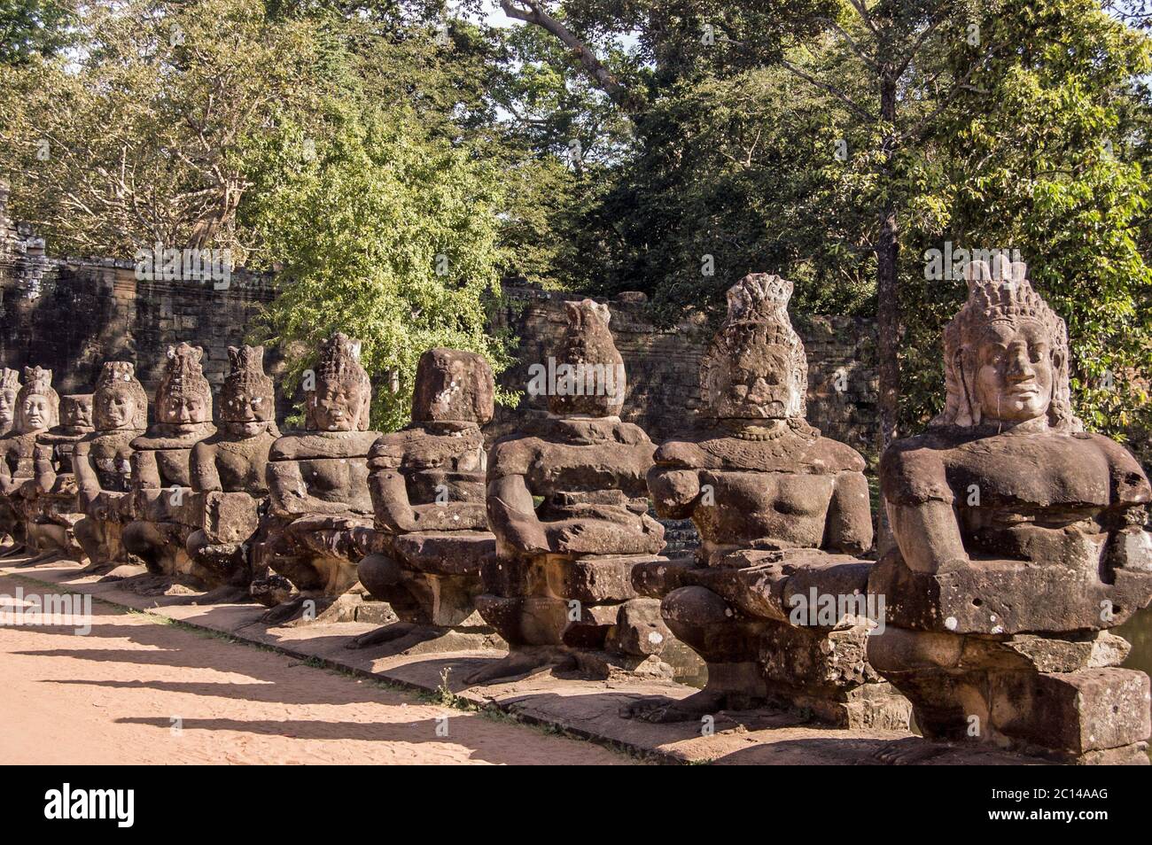 Asuras, o diavoli, tirando il serpente Naga attraverso l'ingresso est cancello di Angkor Thom, Cambogia. Le statue fanno parte di una rappresentazione della Coira Foto Stock