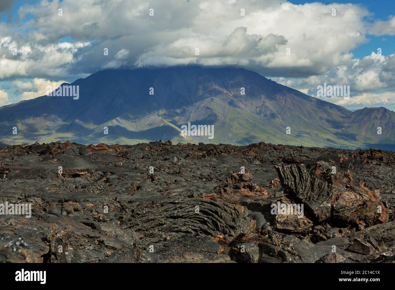 Campo di lava al vulcano Tolbachik, dopo l'eruzione nel 2012 sullo sfondo grande vulcano Udina, Kamchatka Foto Stock