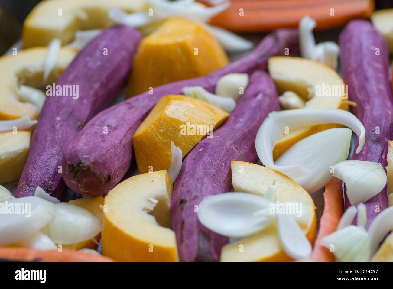 Variopinto mix di verdure di radice: Carote, zucca gialla, patate dolci viola, cipolle e aglio. Foto Stock