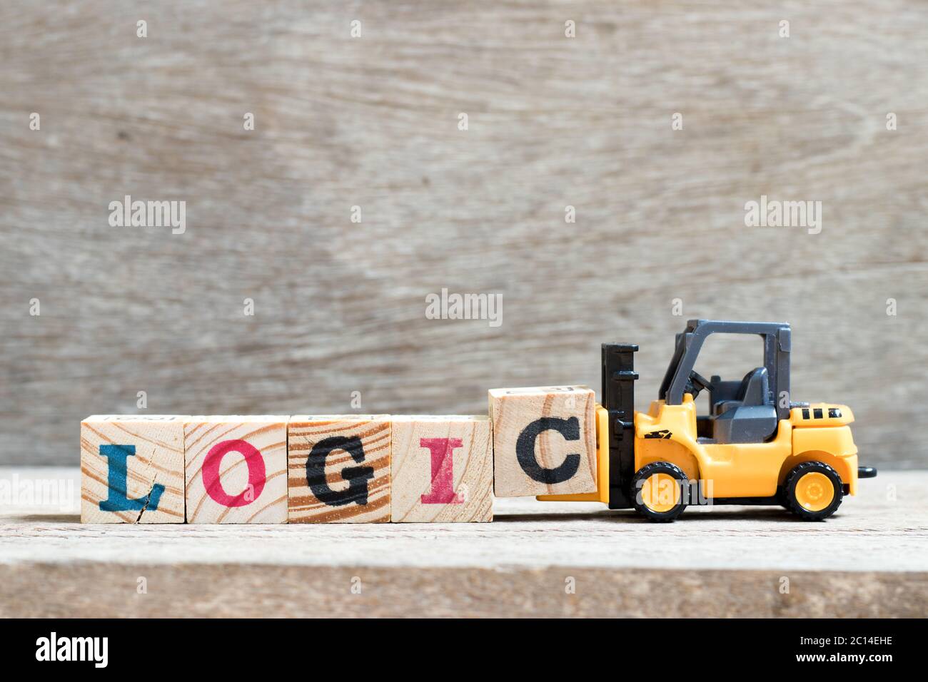 Carrello elevatore giocattolo tenere il blocco di lettera c per completare la logica di parola su sfondo legno Foto Stock