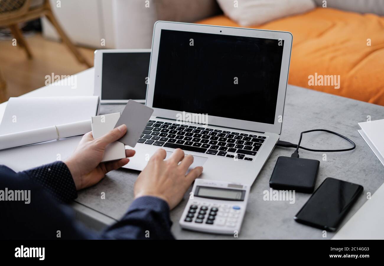 L'uomo d'affari sta usando il laptop e sta analizzando le informazioni finanziarie al suo ufficio. Primo piano di mani maschili che scrivano sulla tastiera del computer. Foto Stock