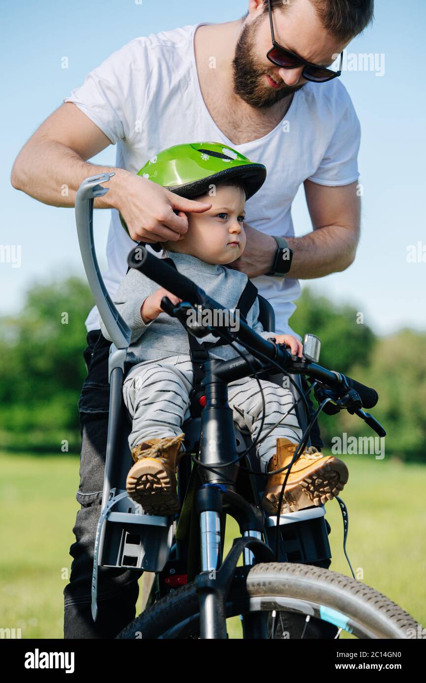 Casco da bici Metodical padre che regge sul suo figlio neonato Foto Stock