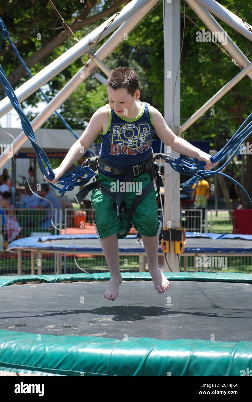 Primo piano di un ragazzo di 7 anni su un bungee trampolino Foto Stock