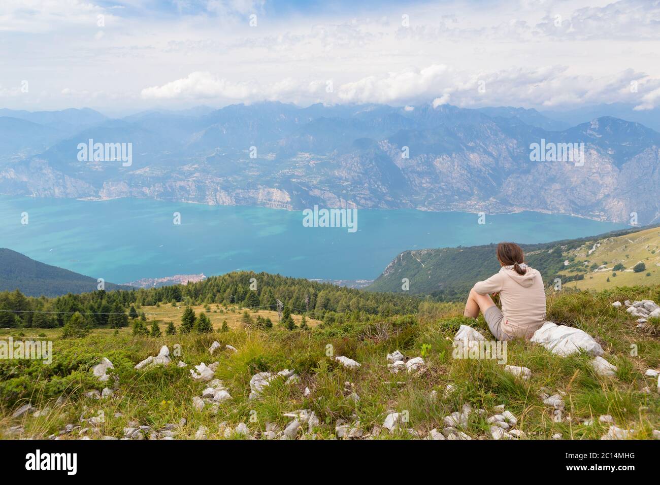 Escursionista godendo della vista dal Monte Baldo sul lago di Garda, Malcesine, Lago di Garda, Italia Foto Stock