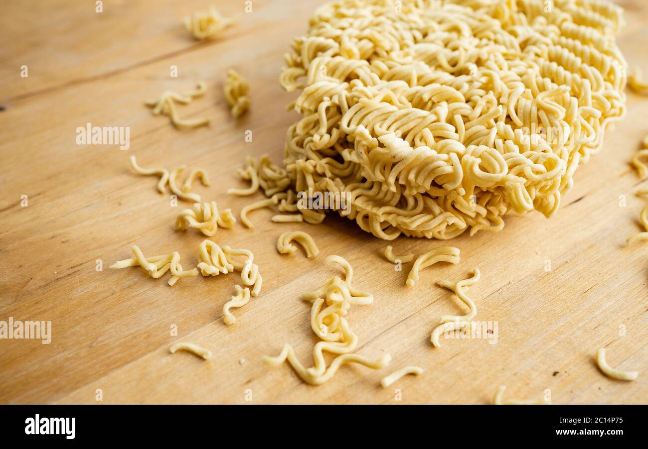 Noodle di cottura veloce su sfondo di legno con spazio di copia. Cibo a buon mercato durante la crisi finanziaria mondiale. Noodle istantanei Foto Stock
