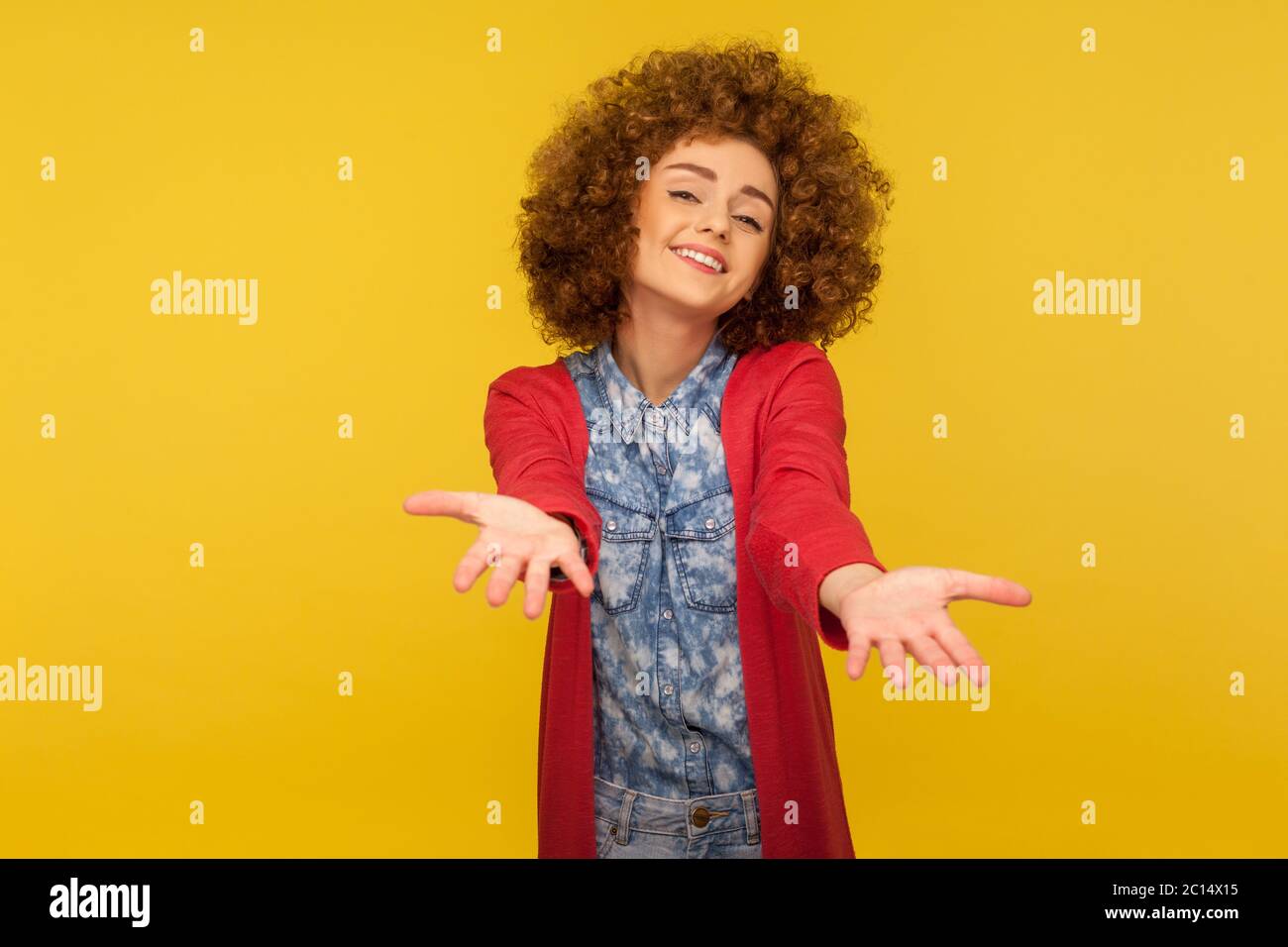 Per favore, prendi gratuitamente! Ritratto di donna generosa gentile con capelli ricci che allungano le mani come se dando per libero, offrendo abbracciare, invitando con h. Foto Stock