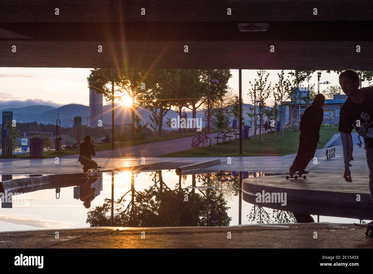 Vienna: skatepark sotto il ponte Reichsbrücke a CopaBeach, skateboarder, tramonto, puddle a causa di un drenaggio non funzionante nel 22. Donaustadt, Wien, Foto Stock