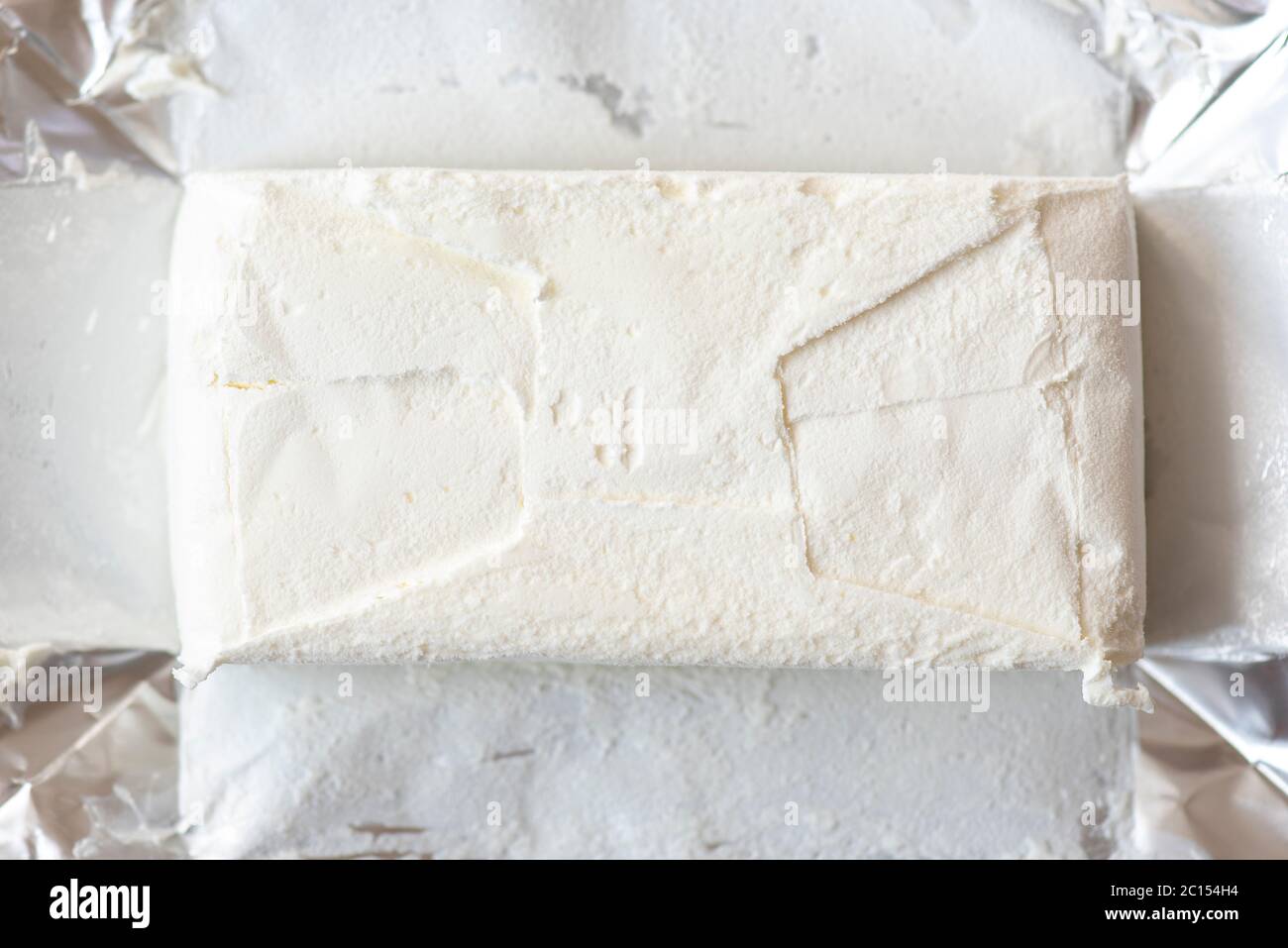 Primo piano di un pacchetto di fogli e gelato bianco congelato, vista dall'alto Foto Stock