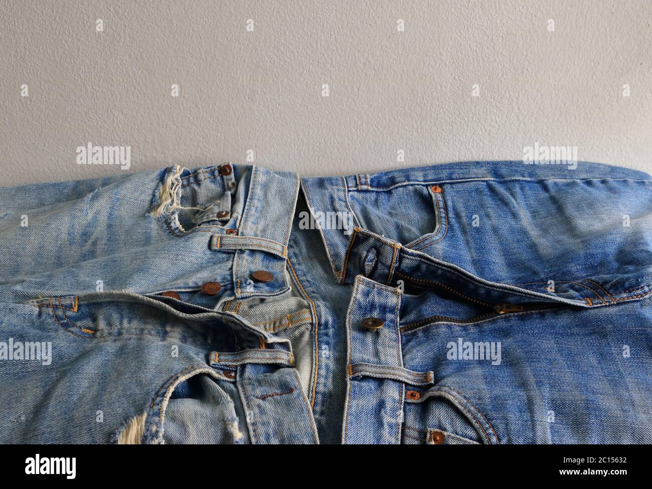 Closeup e fuoco selettivo di jeans mosca di bottone e jeans mosca di zipper in confronto Foto Stock