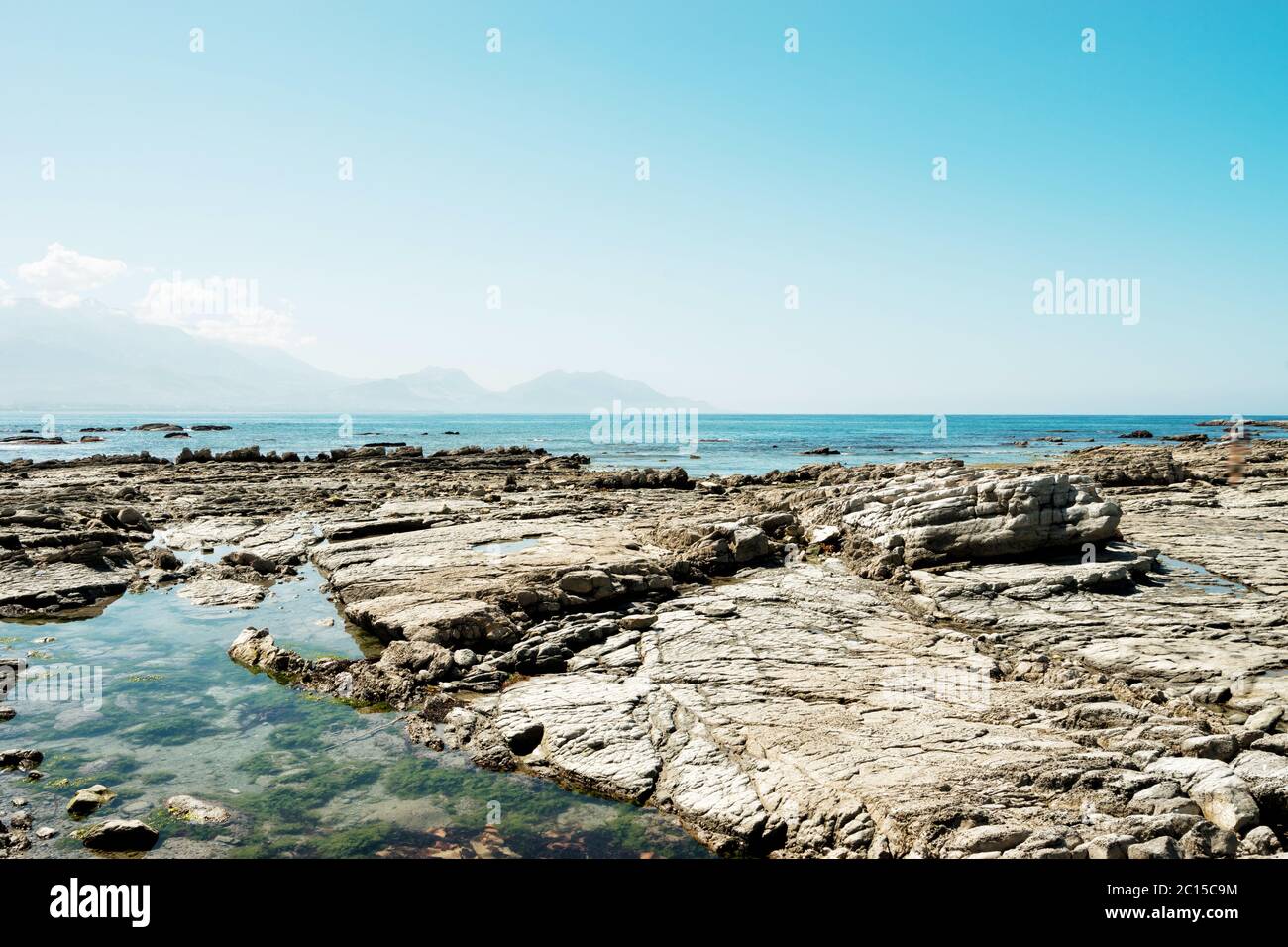 Vuoto spiaggia rocciosa nel cielo blu Foto Stock