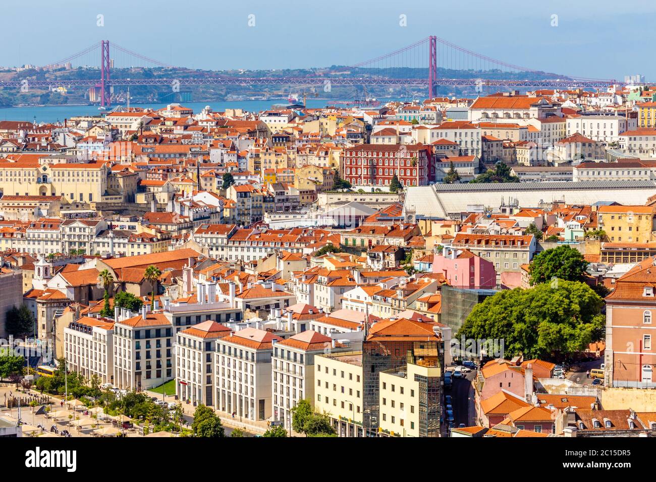 Vista del centro di Lisbona con strade e case mungolli e il ponte del 25 aprile in uno sfondo, Portogallo Foto Stock