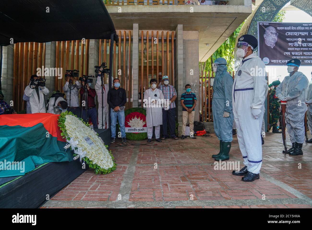 Le guardie d'onore rendono omaggio al defunto ex ministro Mohammed Nasim mentre indossano maschere e guanti come misura preventiva al cimitero di Banani a Dhaka. Foto Stock