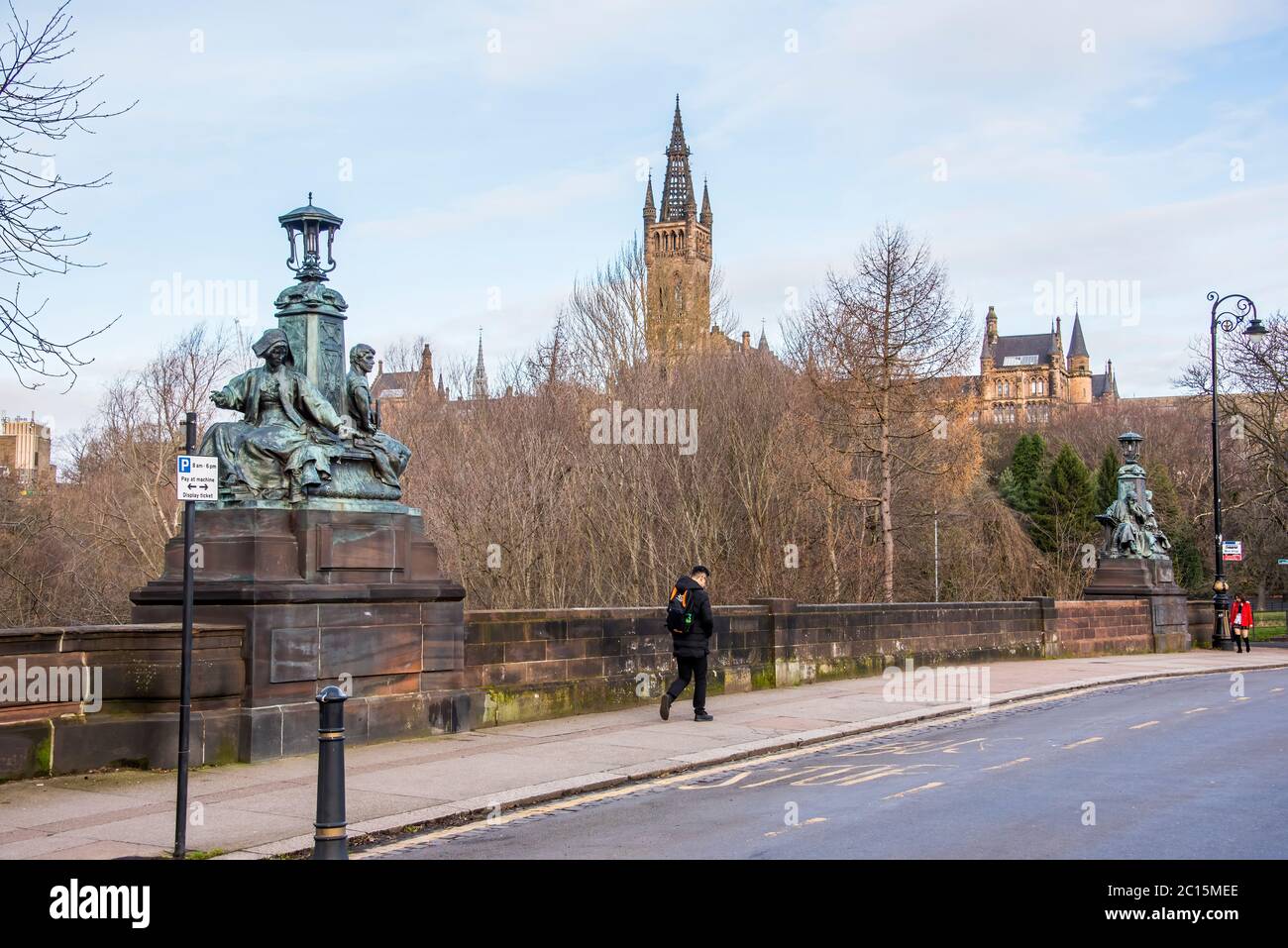 Due delle sculture sul ponte Kelvin Way che si affaccia sulla guglia del palazzo Gilbert Scott della Glasgow University. Foto Stock