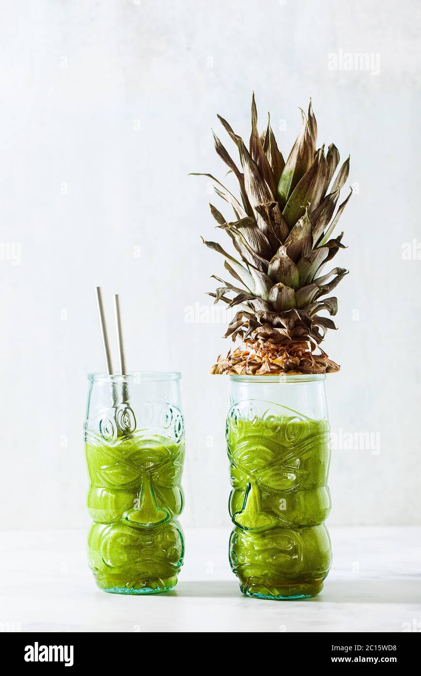Frullato di ananas verde preparato al momento in bicchieri con viso. Colazione sana al mattino. Foto Stock