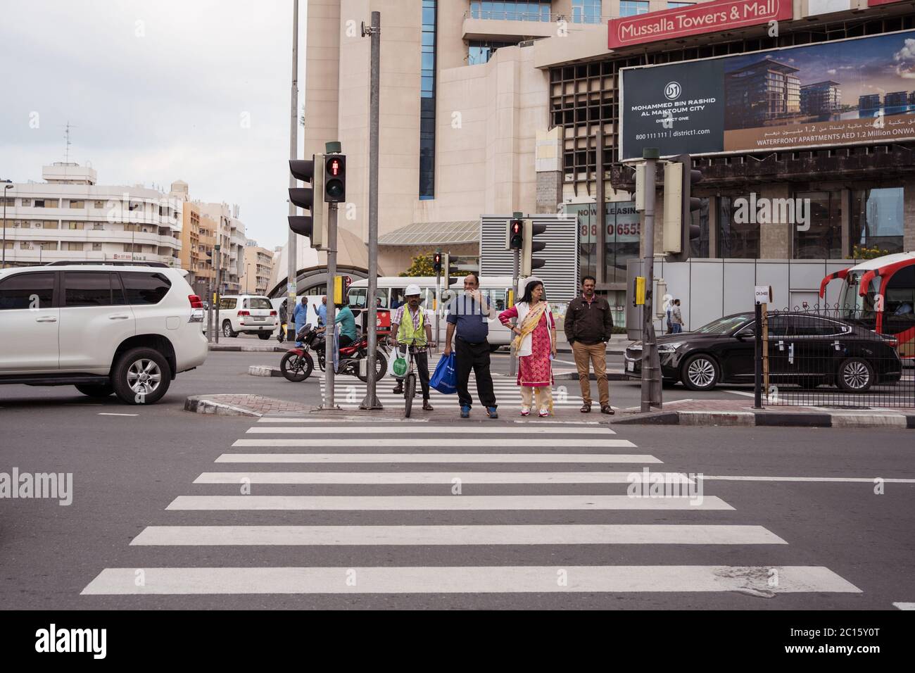 Dubai / Emirati Arabi Uniti - 1 febbraio 2020: Lavoratori immigrati che attraversano la strada in traversata pedonale durante il giorno Foto Stock