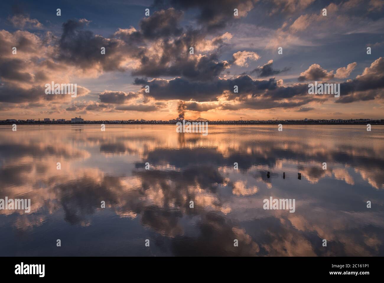 Un tramonto mozzafiato con un cielo pieno di nuvole riflesse nelle acque di un lago salato, San Pedro del Pinatar, Murcia, Spagna Foto Stock