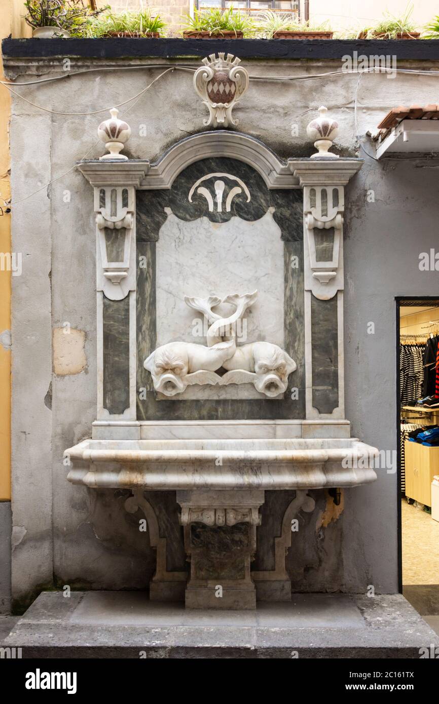 La fontana storica restaurata con lo stemma di Sorrento e il pesce inzitto - 'Schizzariello' sulla Via San Cesareo, Sorrento, Italia Foto Stock