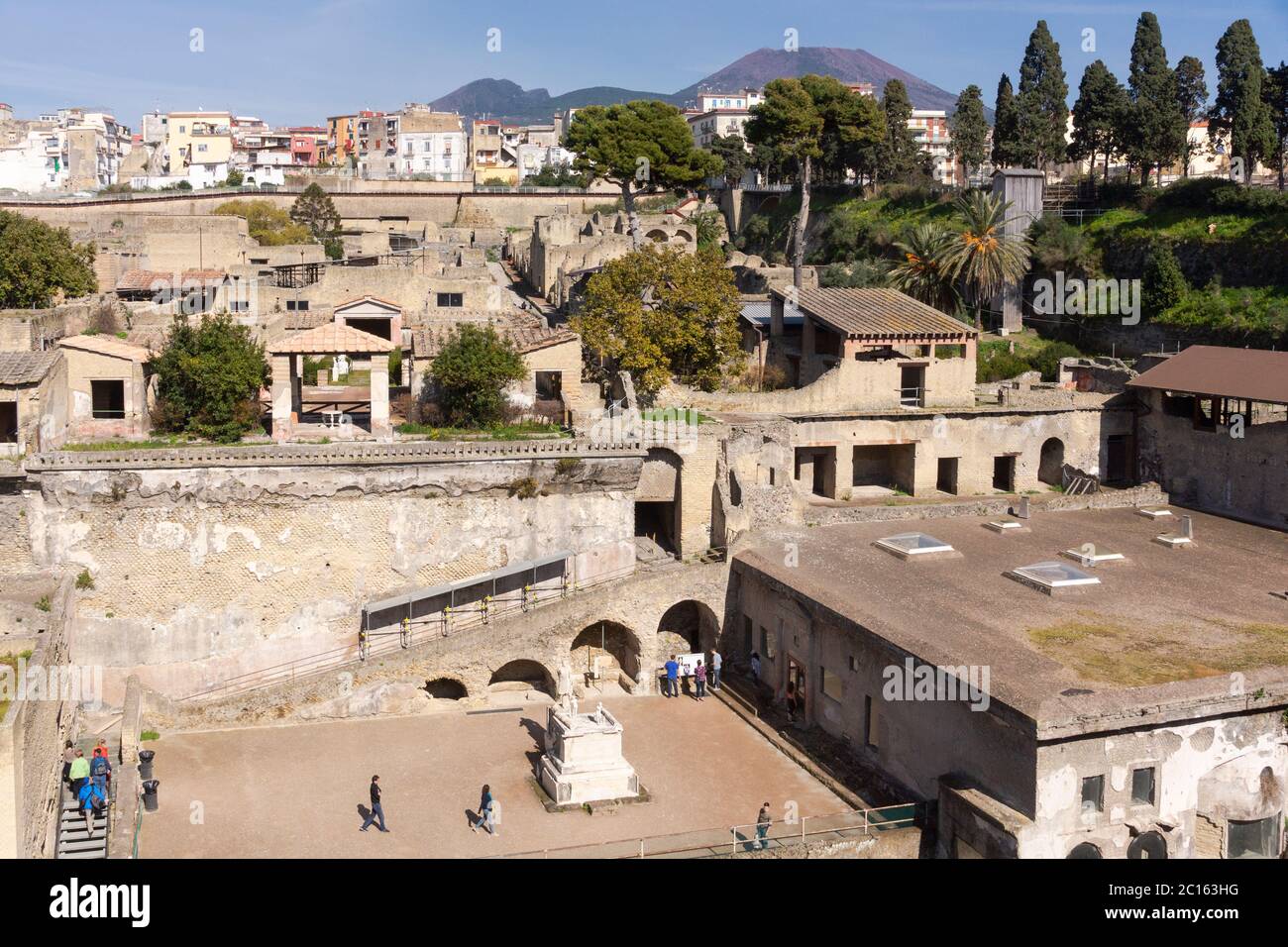 Una vista aerea attraverso le rovine romane e gli scavi dell'antica città di Ercolano (Ercolano) con il vulcano Vesuvio, Campania, Italia Foto Stock