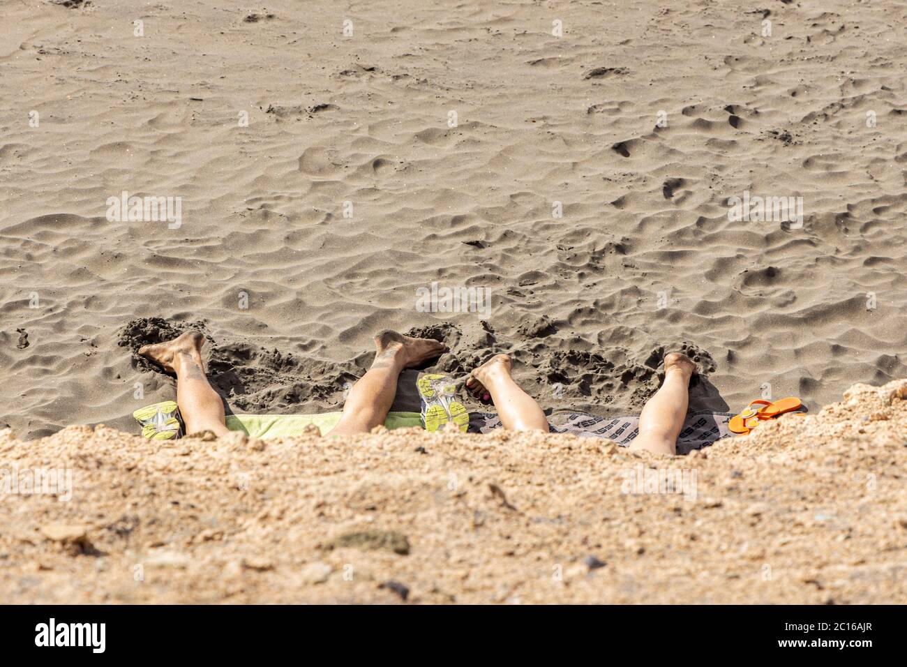 I residenti locali hanno la spiaggia a se stessi come il tempo si fa salire per l'estate. I bagnanti si stendono sulla sabbia. Fase 3 de-escalation del covid Foto Stock