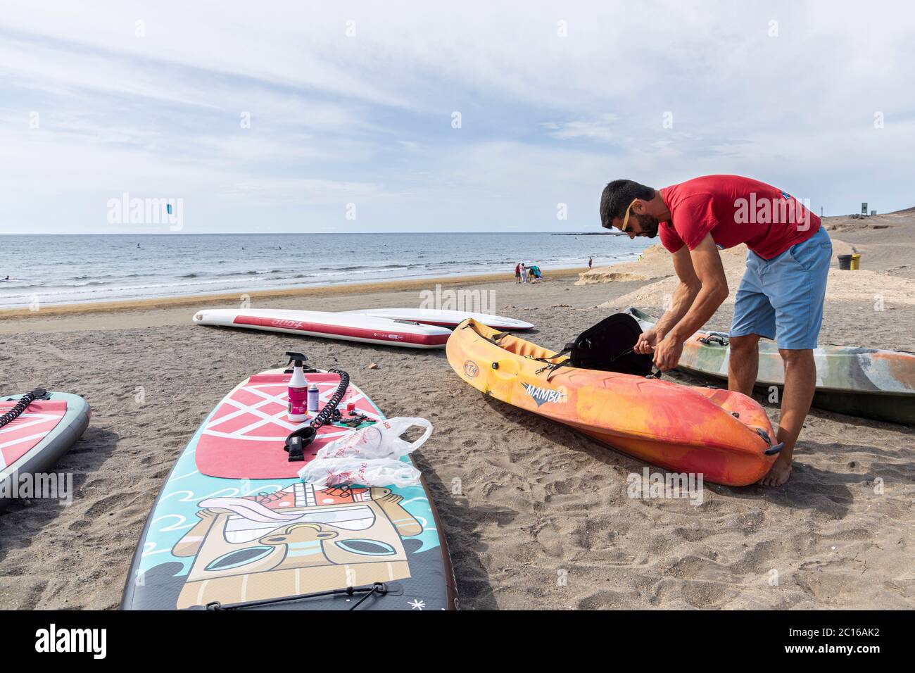 I residenti locali hanno la spiaggia a se stessi come il tempo si fa salire per l'estate. Il proprietario del Red Rock Surf prepara kayak per il noleggio. Deescalation fase 3 Foto Stock