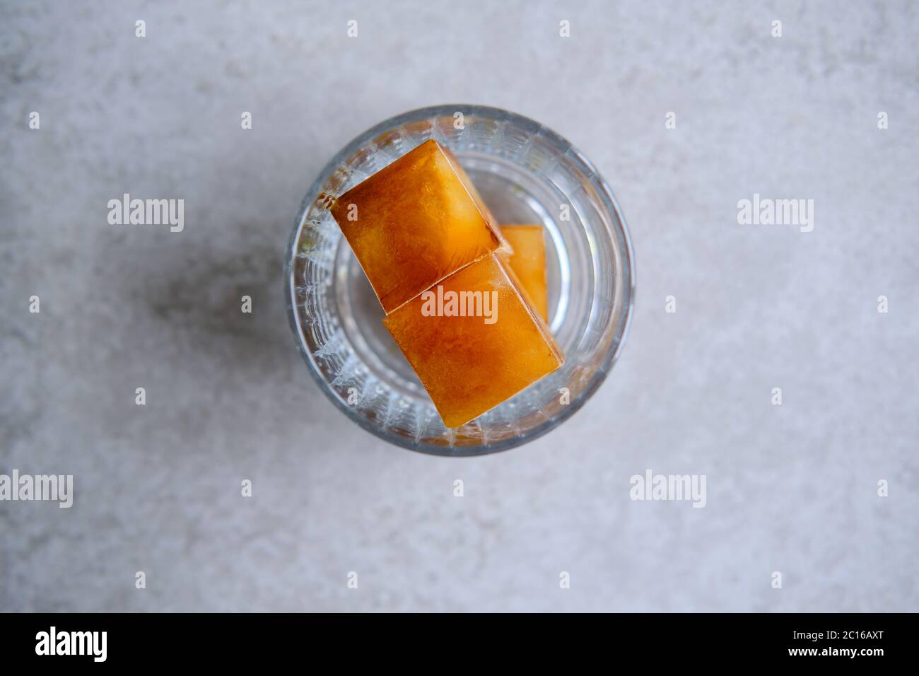 Caffè in bicchiere, cubetti di ghiaccio, latte di cocco, preparazione di una bevanda rinfrescante. Foto Stock