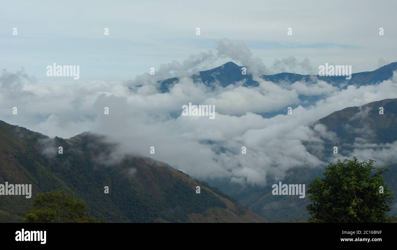Vista panoramica di una montagna circondata da nuvole con cielo nuvoloso. Paesaggio in provincia di Bolivar in Ecuador Foto Stock