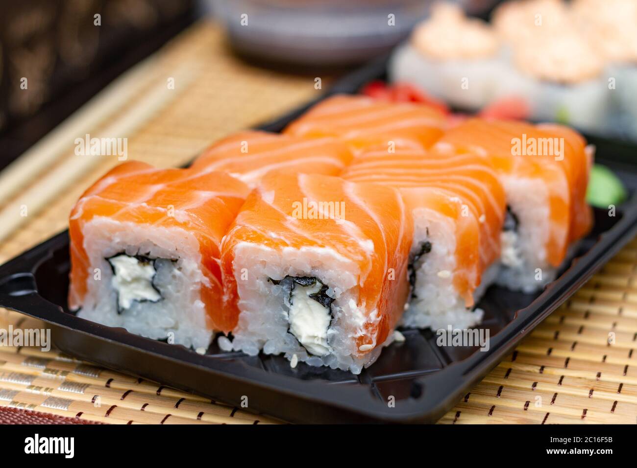 Panini di sushi su una piastra di plastica. Consegna di cibo asiatico a casa. Foto Stock
