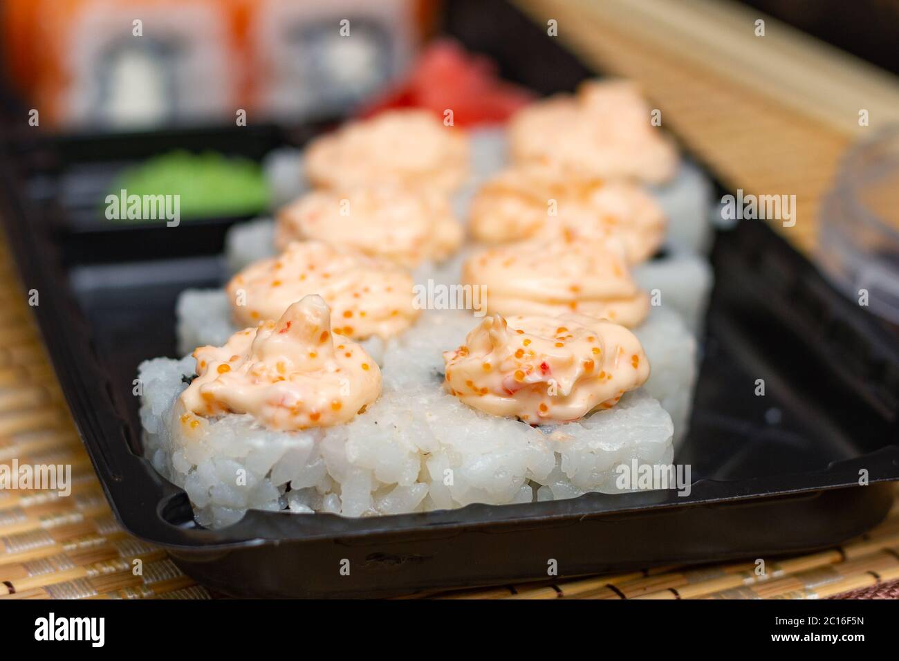 Panini di sushi su una piastra di plastica. Consegna di cibo asiatico a casa. Foto Stock