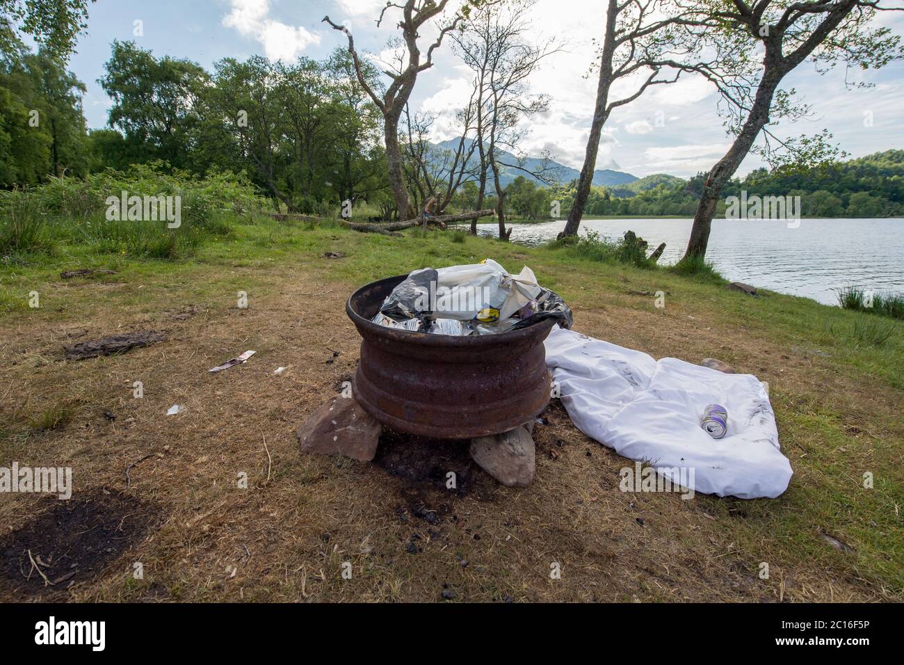 Loch Achray, Loch Lomond e Trossachs National Park, Scozia, Regno Unito. 14 Giugno 2020. Nella foto: Le rive del lago Achray sono disseminate di rifiuti in dumping come sacchetti di plastica, lattine di birra vuote, abbigliamento da campeggio e resti di droga. Loch Achray è sulla Heart 200 Route, tuttavia è stato chiuso durante il blocco di Coronavirus (COVID19). Il blocco non ha fermato le persone che si accamparono illegalmente e anche illegalmente lasciare la loro lettiera sinistra che rappresenta un rischio per la fauna locale. Credit: Colin Fisher/Alamy Live News Foto Stock