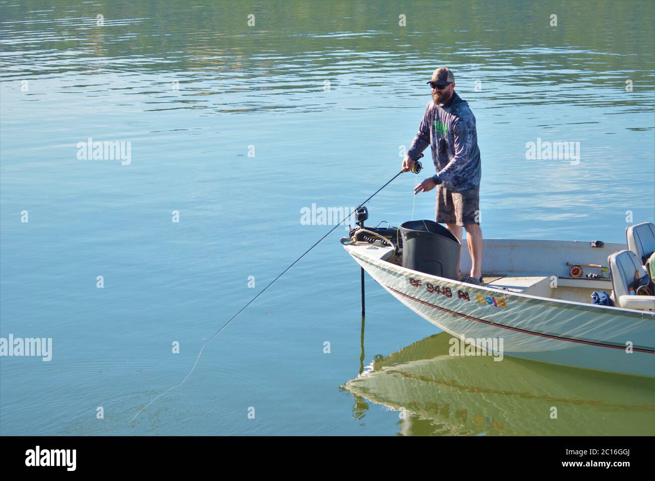 Uomini solitari che pescano durante Covid 19 problemi in California da lui stesso su Clearlake Foto Stock