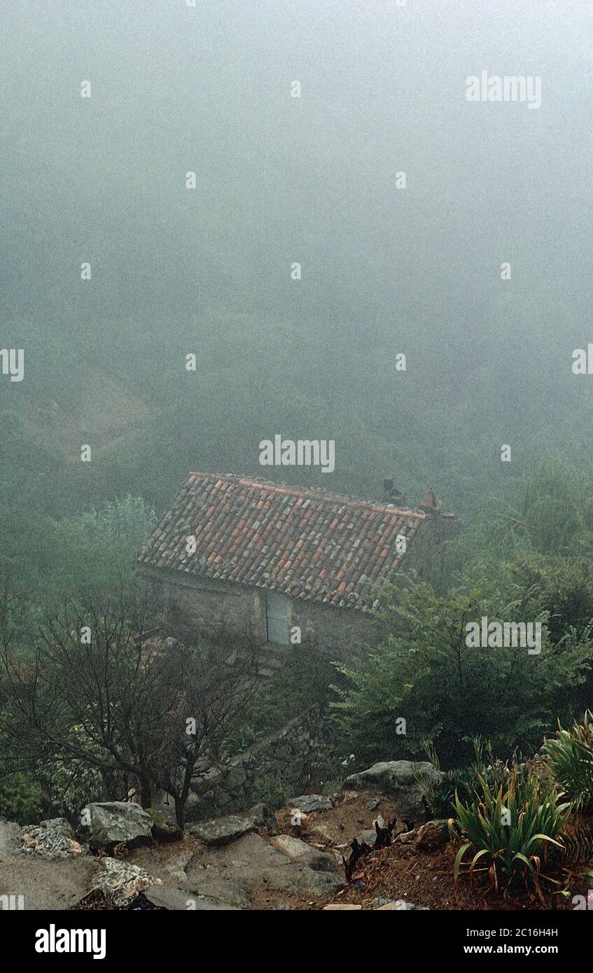 Illustrazione fotografica. Vista romantica di una casa in collina in una nebbia. Sartene in Corsica del Sud, Francia 1980 Foto Stock