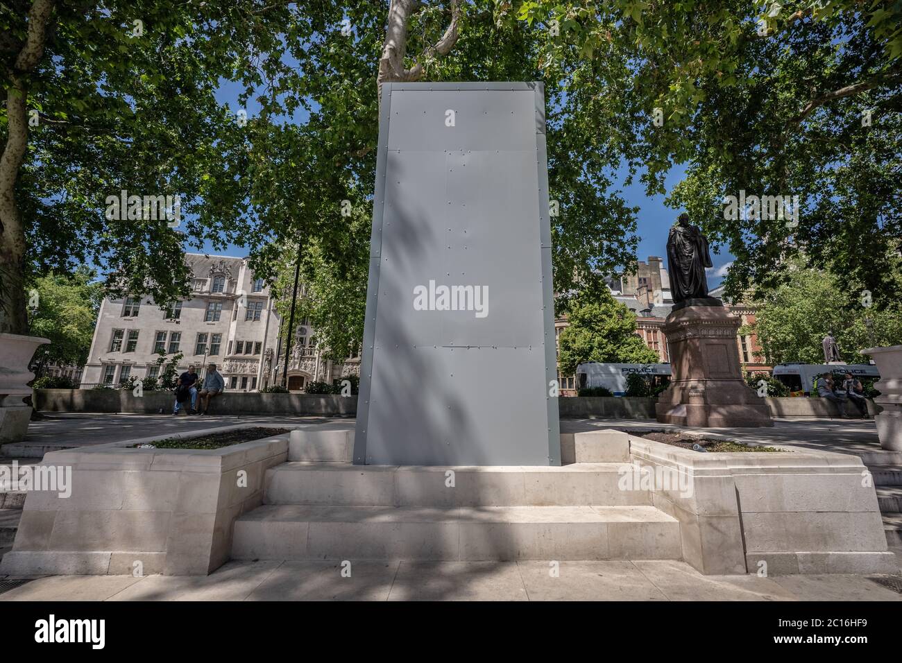 La statua commemorativa di Gandhi è circondata da rivestimenti protettivi in Parliament Square, Londra, Regno Unito. Foto Stock