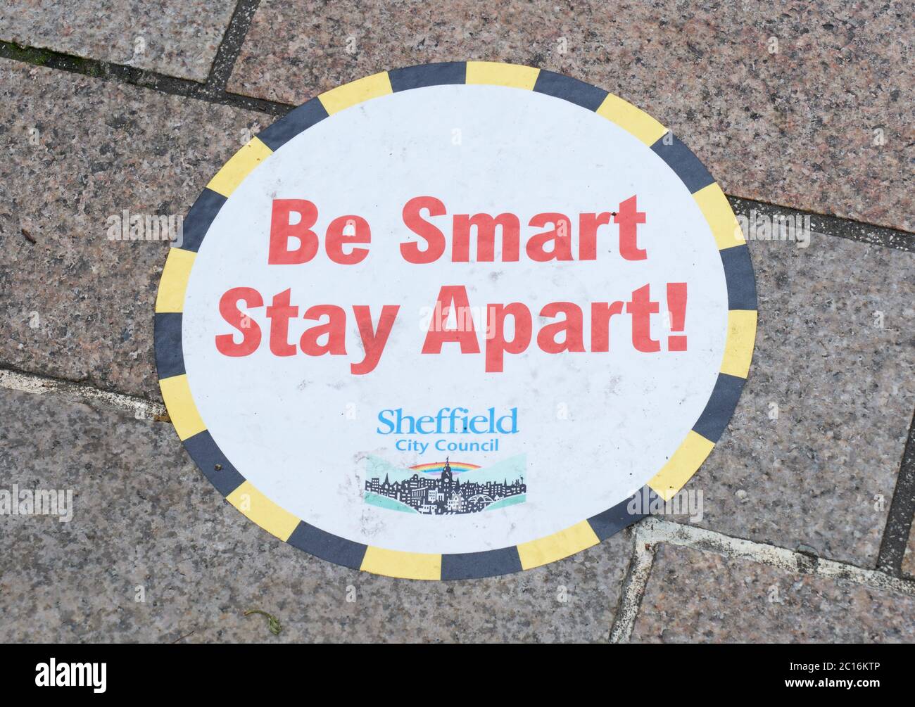 Adesivo autoadesivo a distanza sociale sul marciapiede in strada pedonale in preparazione per i negozi che si aprono il 15 giugno 2020 Foto Stock